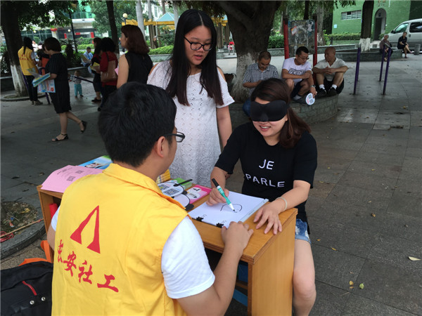 图为社区居民在体验蒙眼画像游戏